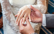 Groom placing ring on brides finger