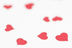 Multi soft red hearts scattered on a white background