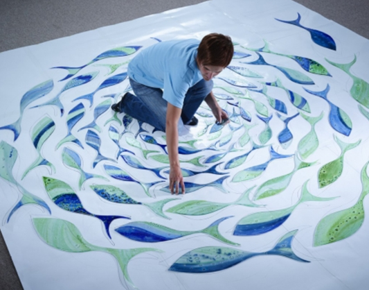 Jo Downs, Glass Art Designer, arranging shoal of glass fish