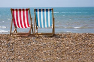 Striped Striped deckchairs on a pebble beach by the sea